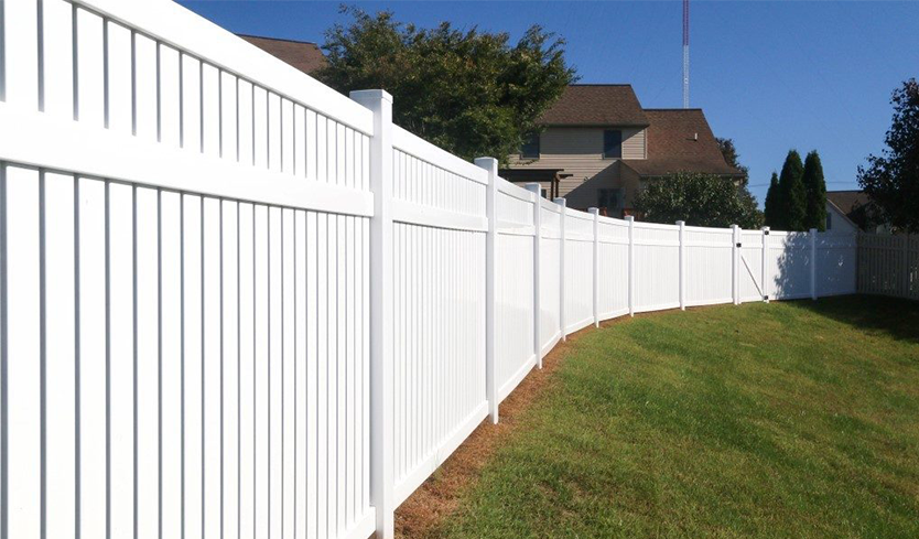 A white fence installed in a residential neighborhood, enhancing the property’s boundary and aesthetic appeal.
