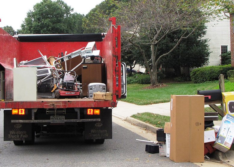 A trash removal truck parked on the side of the road, ready for service.